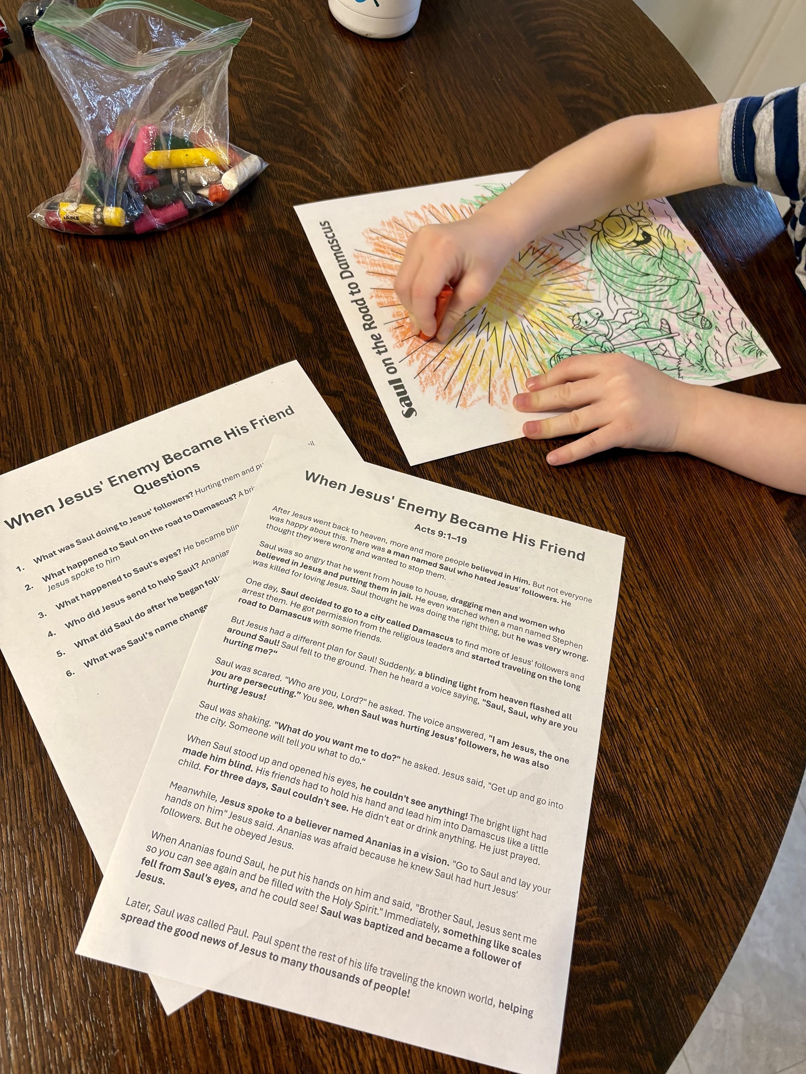 A child coloring a sheet from the family Bible guide